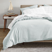 A modern bed with an organic sateen duvet cover set on.