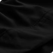 Close up of a black microfiber sheet showing the stitching and texture