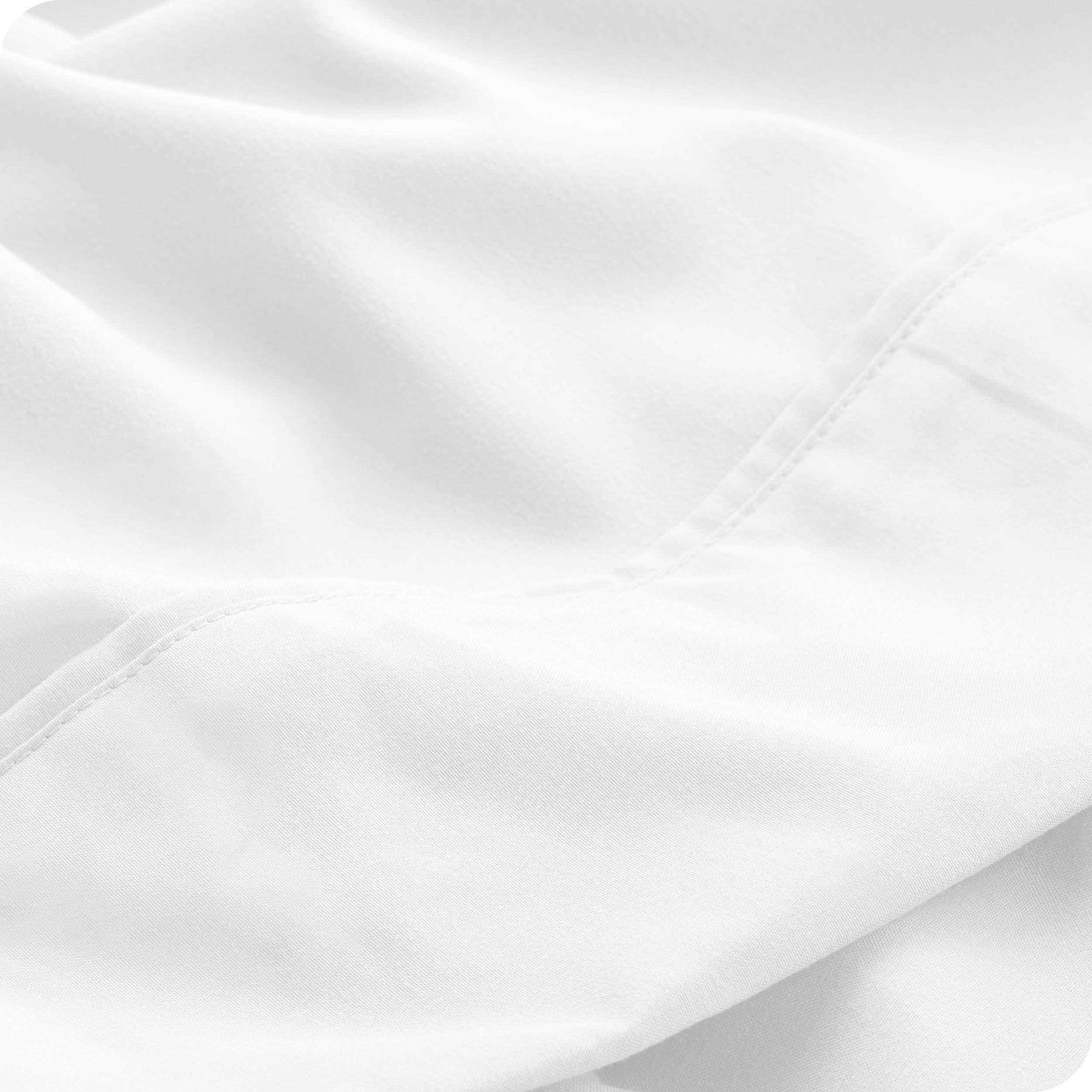 Close up of a white microfiber sheet showing the stitching and texture