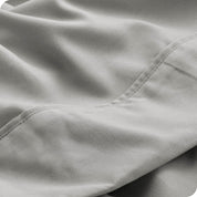 Close up of a light grey microfiber sheet showing the stitching and texture
