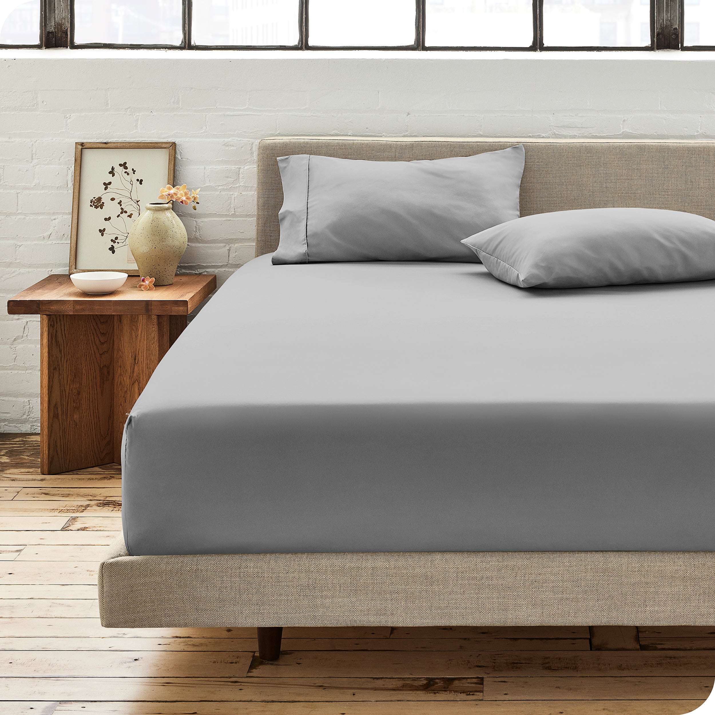 Modern bedroom with bed showing light grey percale fitted sheet