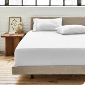 Modern bedroom with bed showing white percale fitted sheet