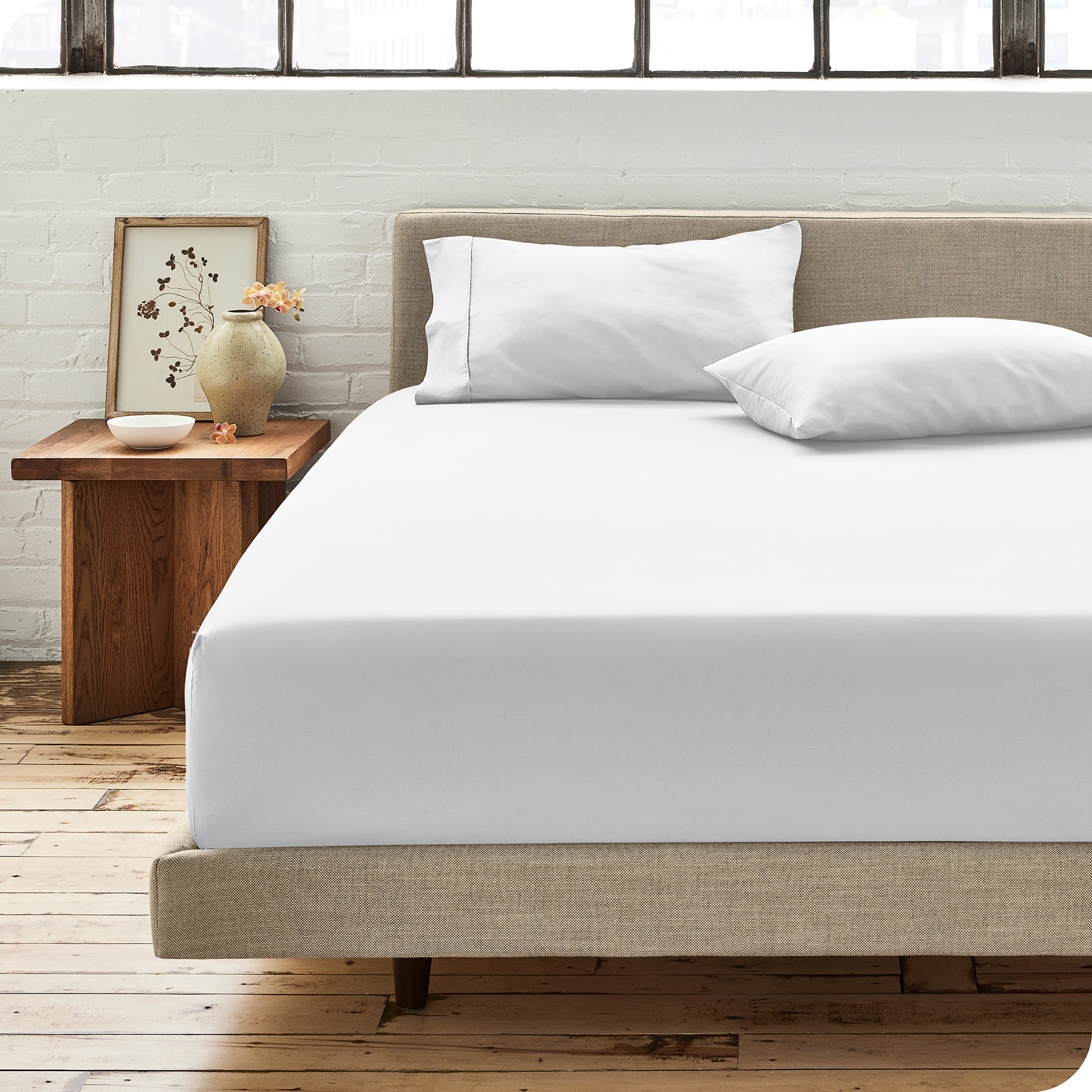 Modern bedroom with bed showing white percale fitted sheet