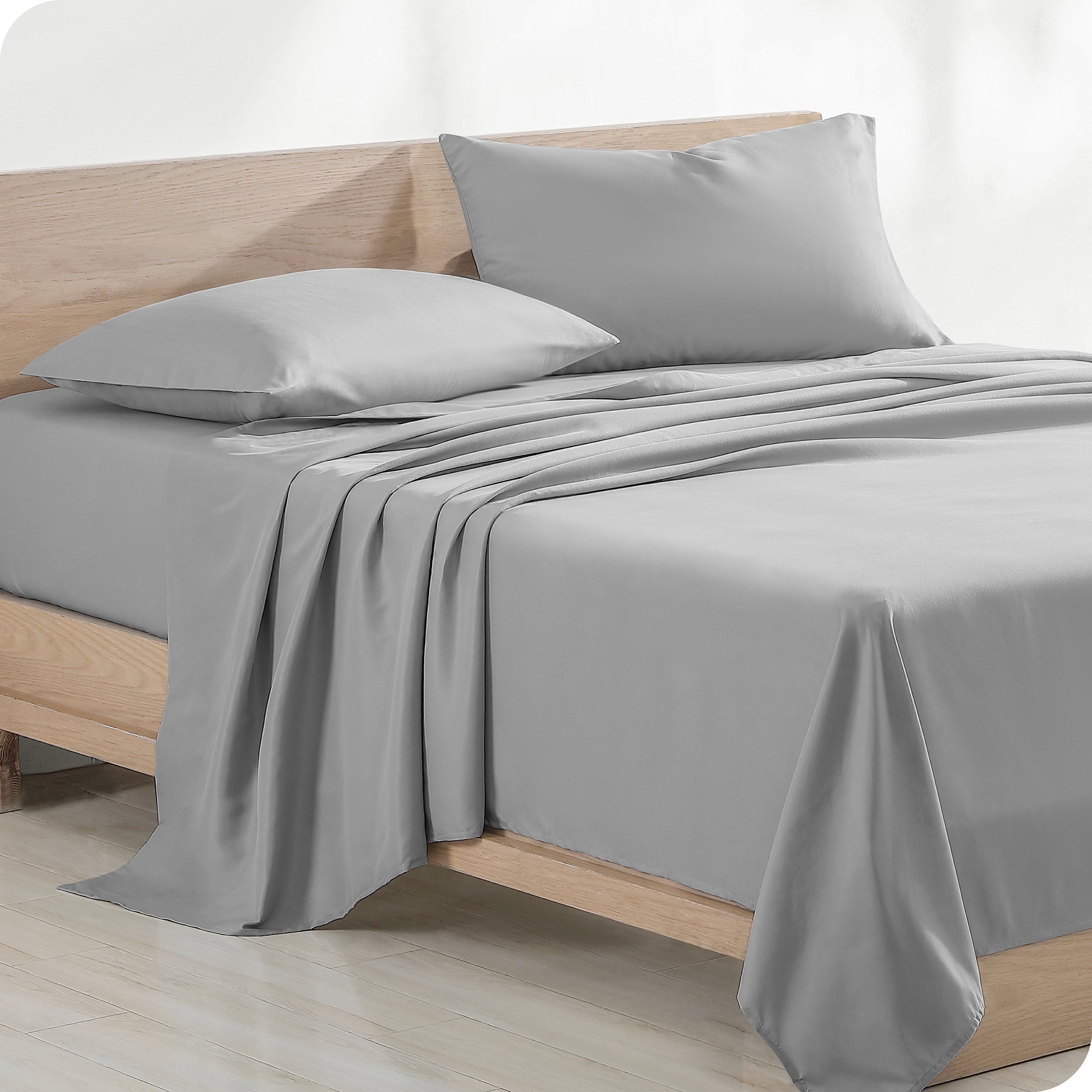 Diagonal view of modern wood bed with sheets and pillows