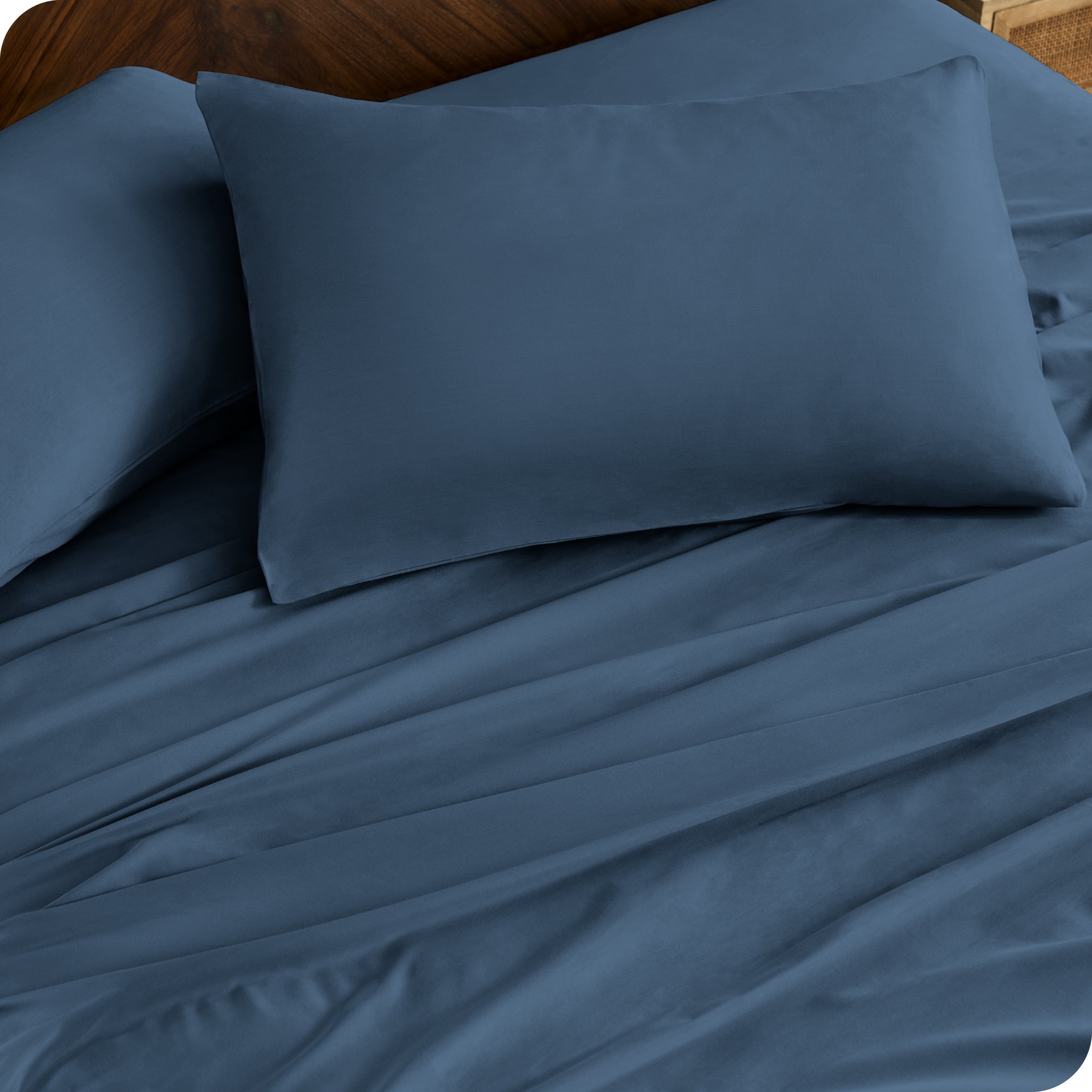 Close up of percale pillowcases and sheets on a bed