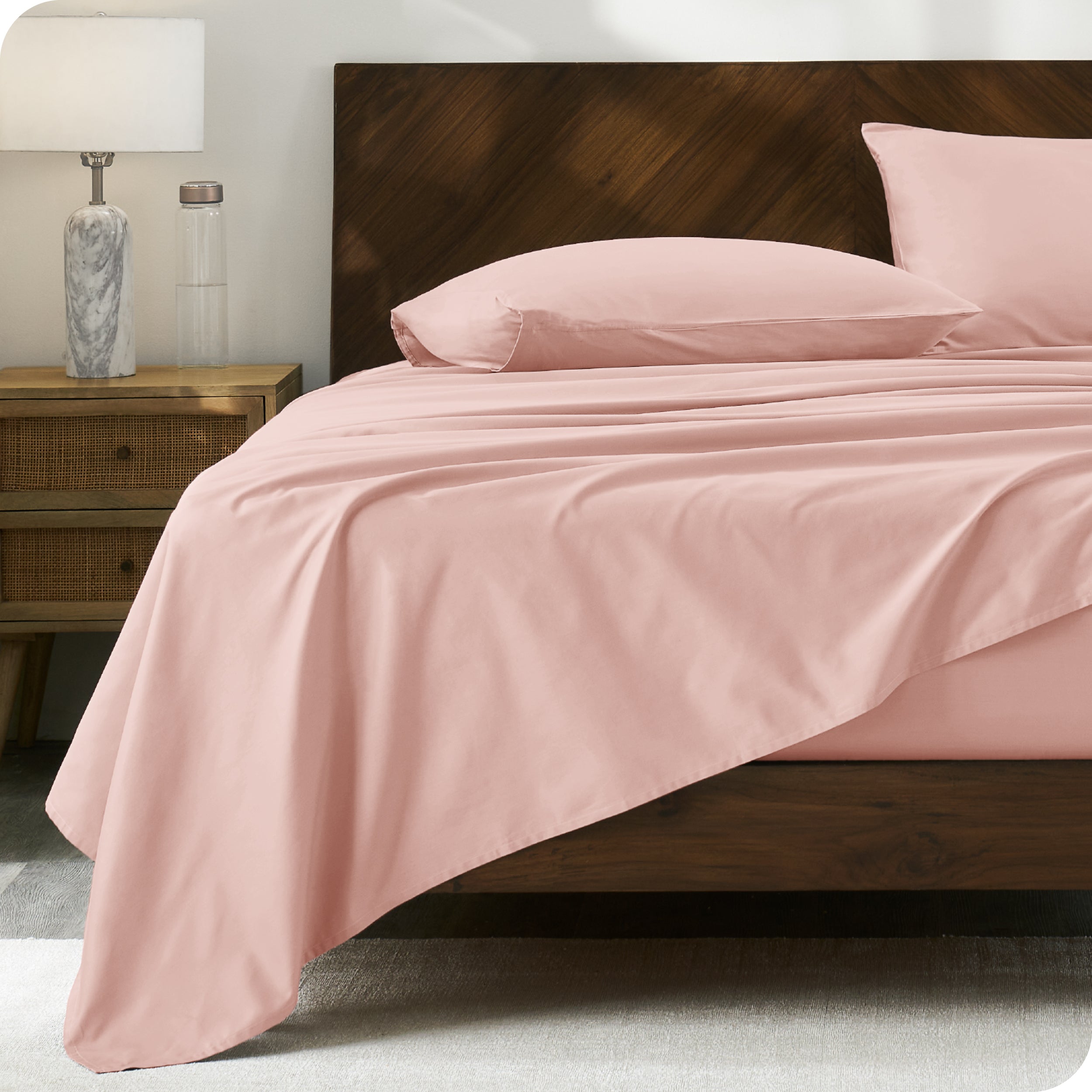 Modern wood bed with percale sheets and pillowcases