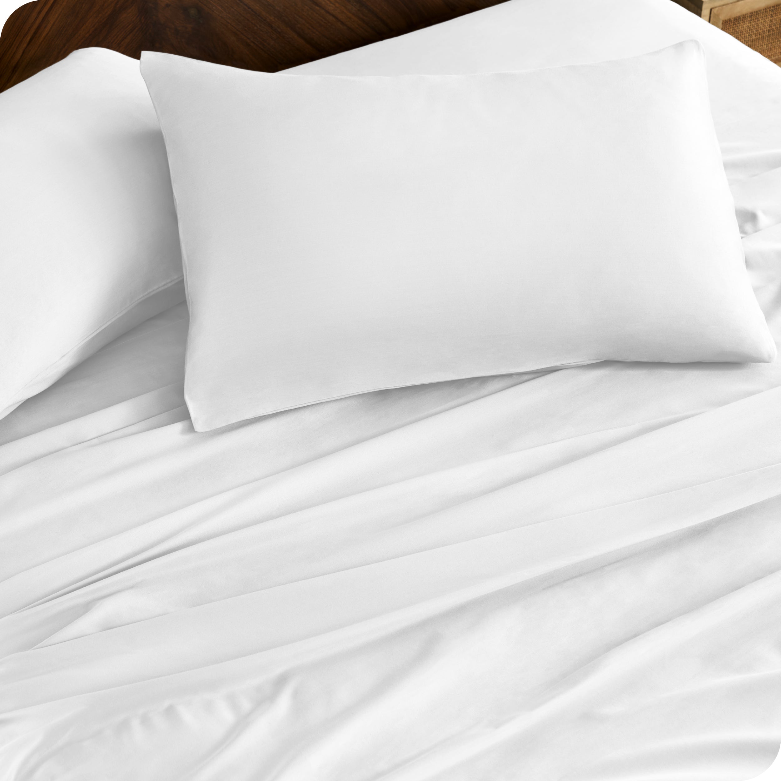 Close up of percale pillowcases and sheets on a bed