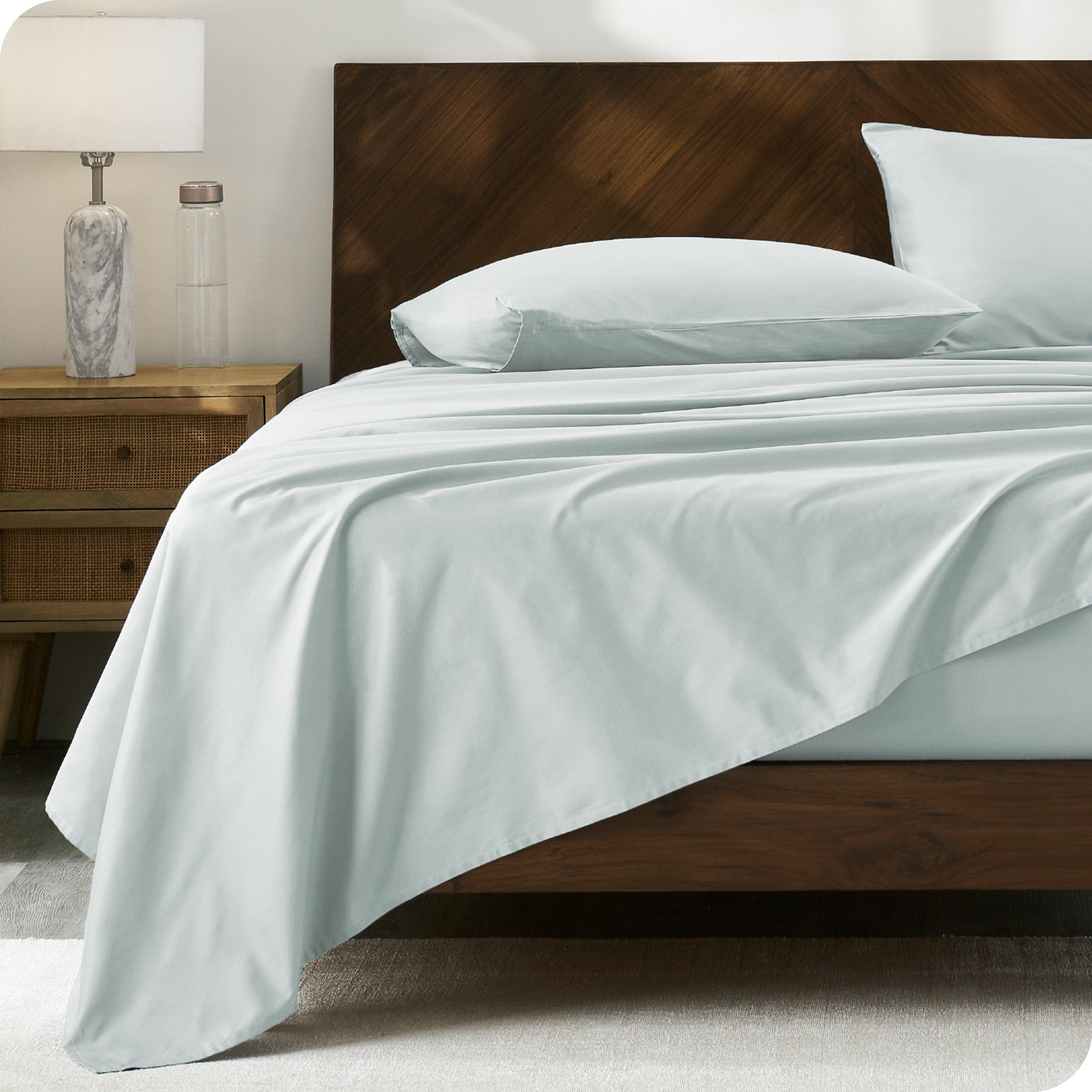 Modern wood bed with percale sheets and pillowcases