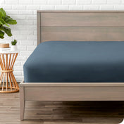 Modern wood bed frame with a sateen fitted sheet on the mattress