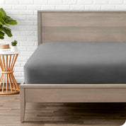 Modern wood bed frame with a sateen fitted sheet on the mattress