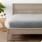 Modern wood bed frame with a sateen fitted sheet on the mattress