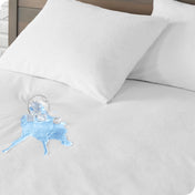 A glass of water spilled on a mattress protector. There are two pillows with protectors on the mattress.