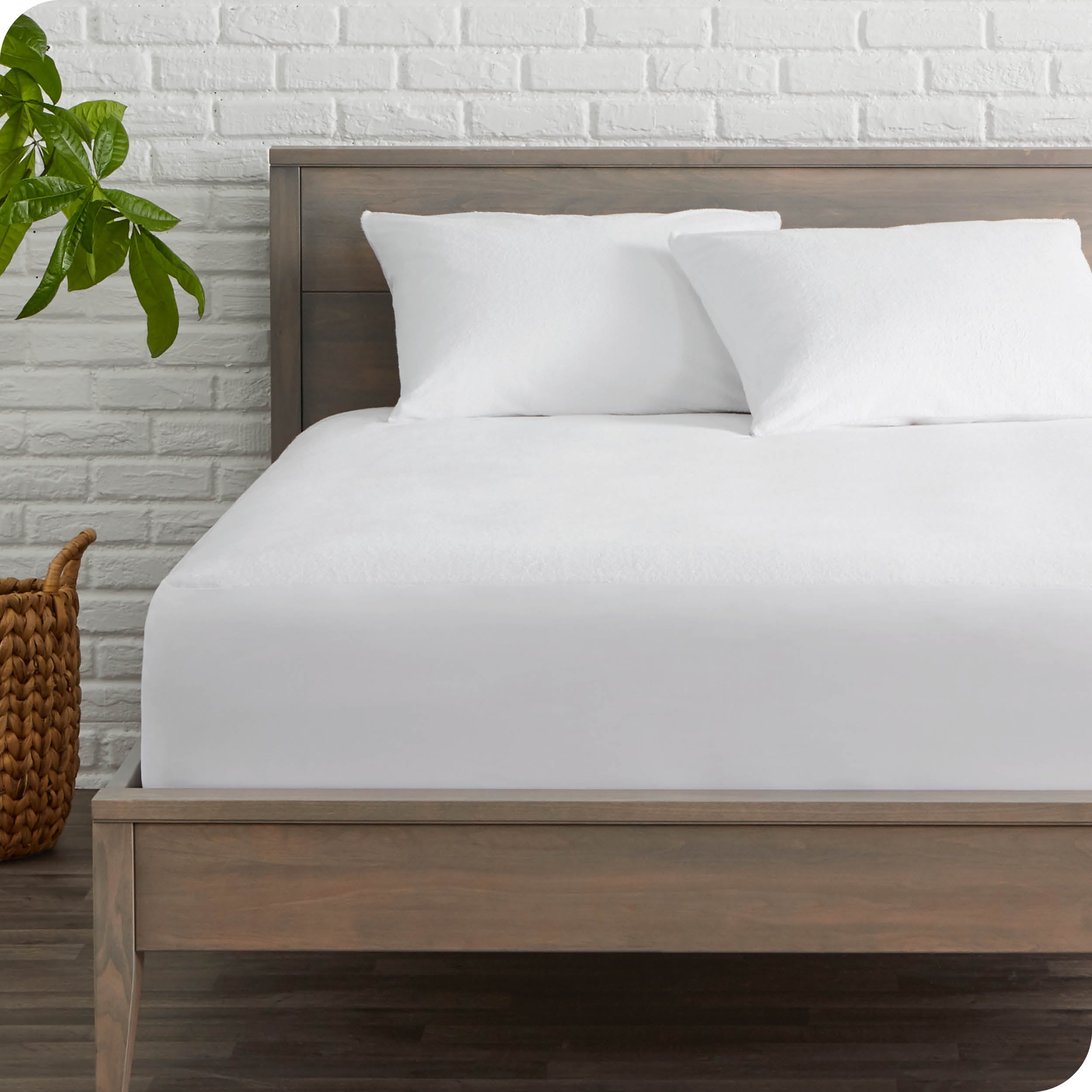 Pillow protectors covering pillows on a bed with a mattress protector